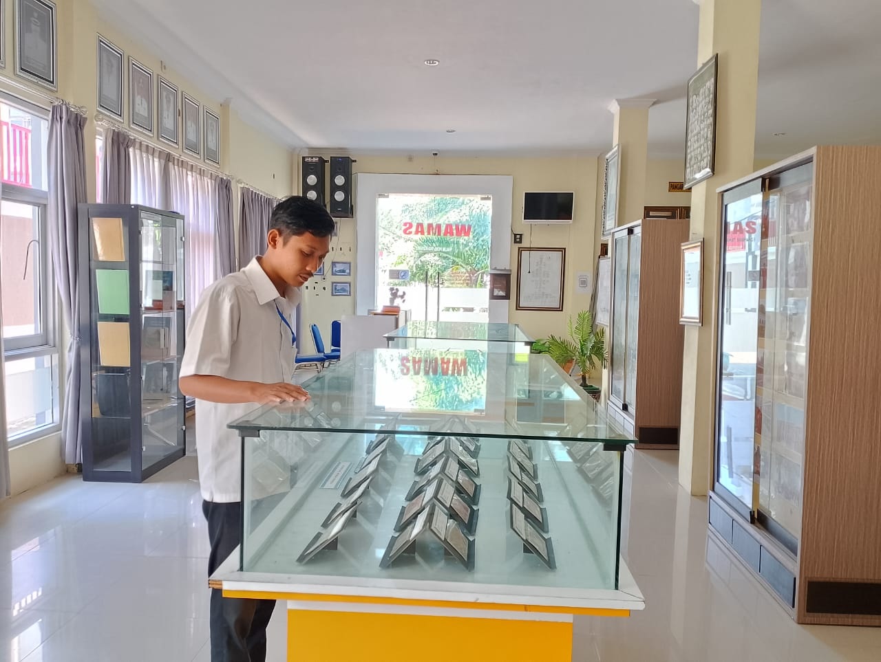 PENGUNJUNG FLUKTUATIF: Karyawan Dispusip Sampang mengecek arsip di Wamas Sampang, Selasa (14/5).