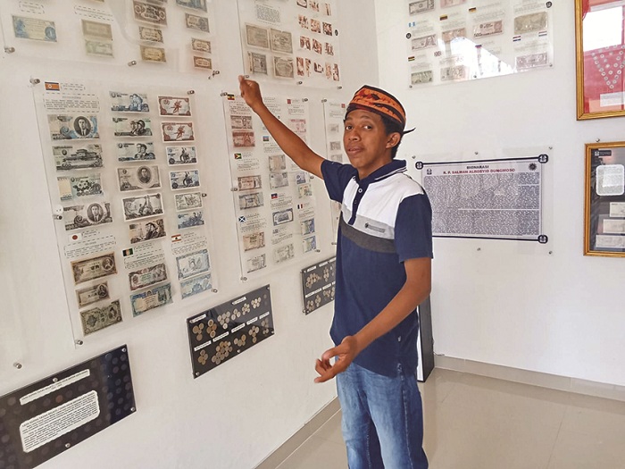 BENDA BERSEJARAH: Owner Museum Perusnia Salman Alrosyid Dungmoso menunjukkan koleksi koin zaman kerajaan di Museum Perusnia, Jalan KH Moh. Kholil, Demangan, Kecamatan Bangkalan, Minggu (19/5).
