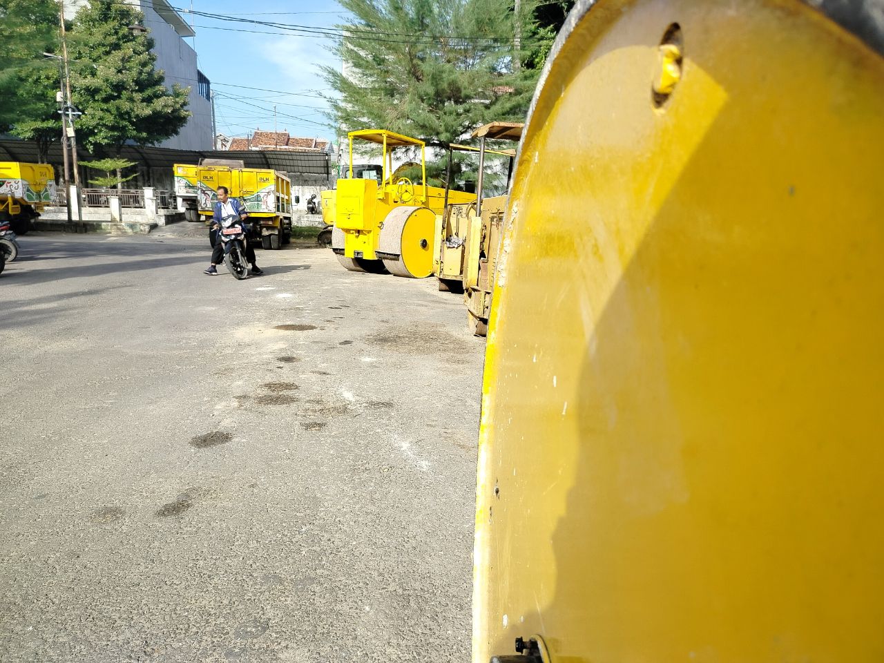BELUM DIPAKAI: Pegawai melintas di sekitar alat berat milik DPUPR Pamekasan, Rabu (22/5). (LAILIYATUN NURIYAH/JPRM)