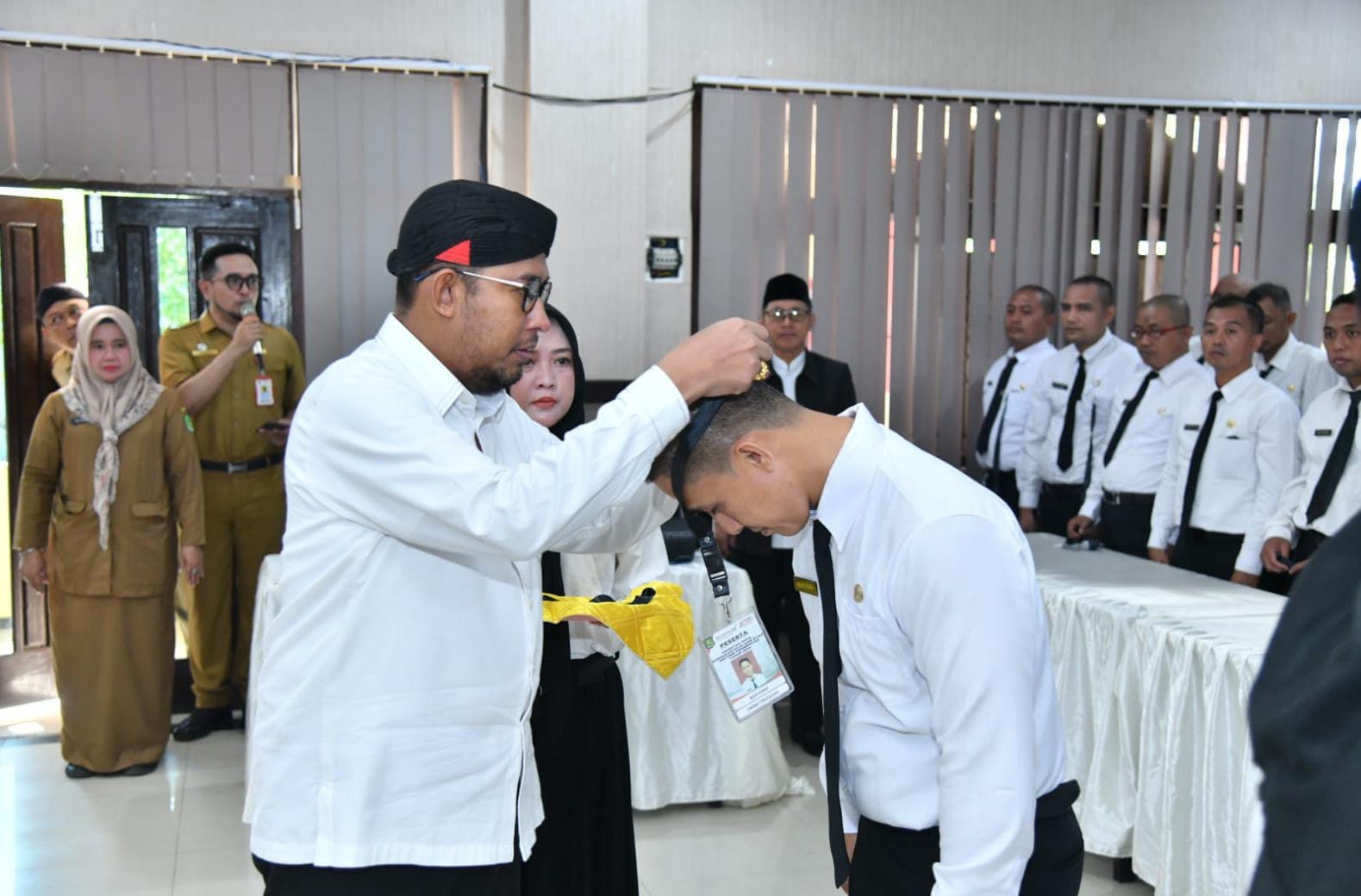 BERJALAN LANCAR: Bupati Sumenep Achmad Fauzi Wongsojudo mengalungkan tanda pengenal kepada PPPK yang mengikuti Orientasi Kurikulum Nilai dan Etika Instansi Pemerintahan di kantor SKB Batuan.
