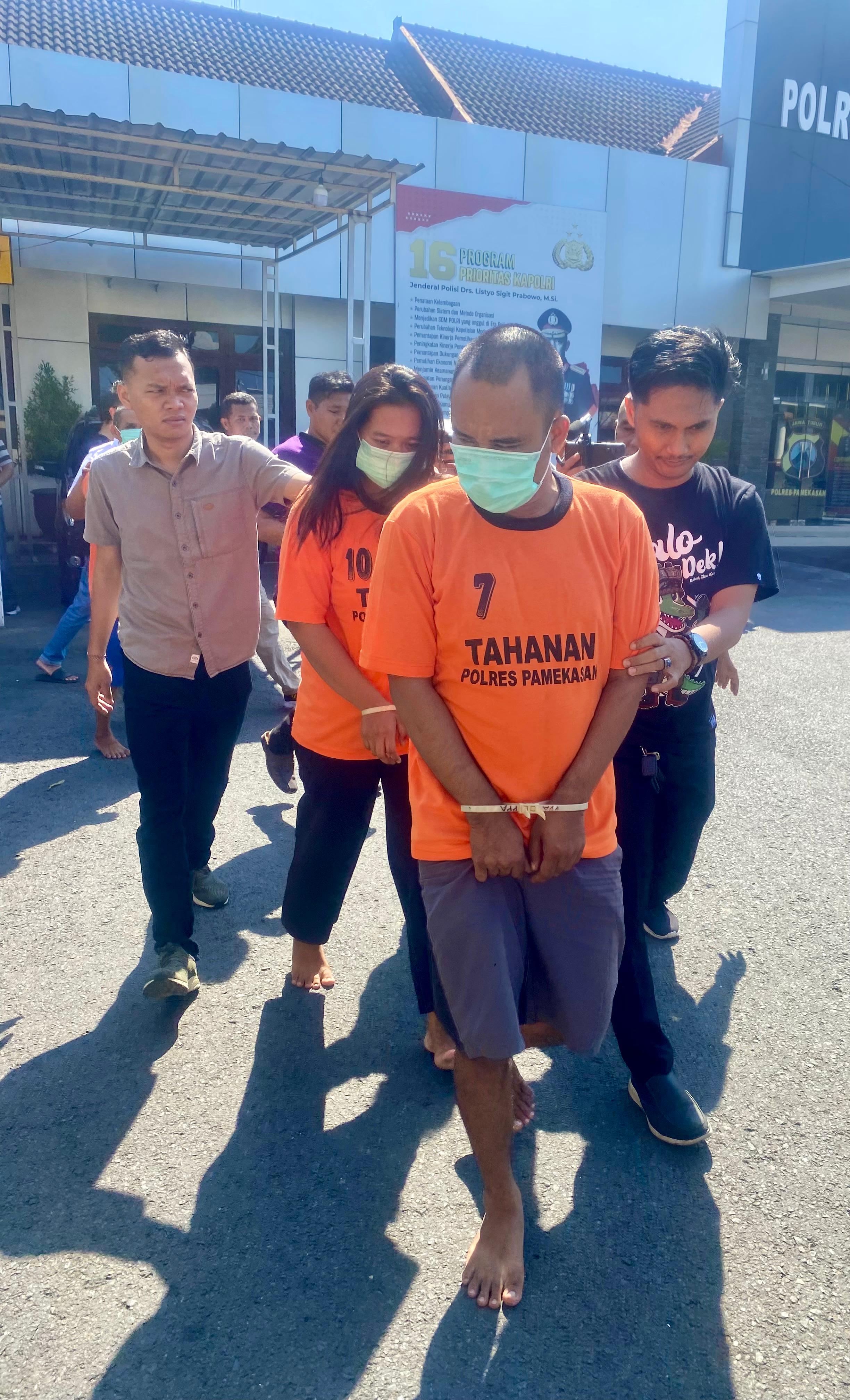 NEKAT: Pasutri Trian Adi Gunawan dan Noer Aini Slamet digiring petugas untuk dihadirkan dalam konferensi pers Polres Pamekasan, Senin (27/5). (MOH. IQBAL AFGANI/JPRM)