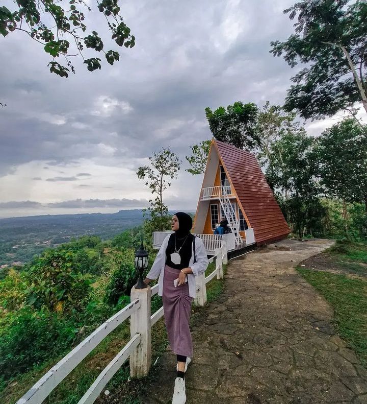 Seorang Pengunjung Sedang Menikmati Pemandangan di Puncak Ratu Pamekasan