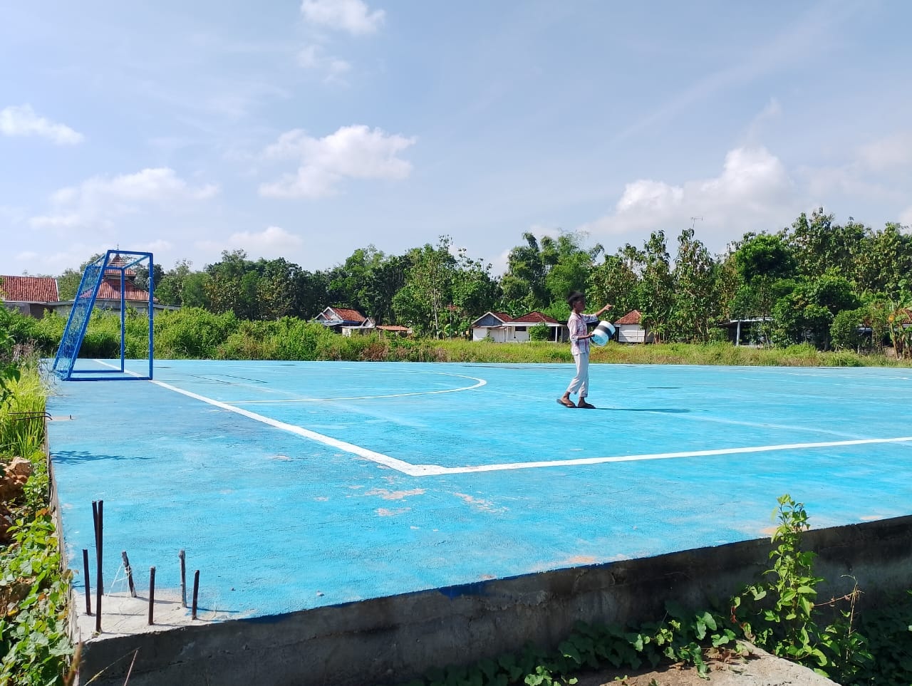 TIDAK BERTAHAN LAMA: Seorang bocah bermain layangan di lapangan futsal Desa Karang Penang Onjur, Kecamatan Karang Penang, Sampang, yang sudah retak, Kamis (23/5). (UBAIDILLAHIR RA&rsquo;IE/JPRM)