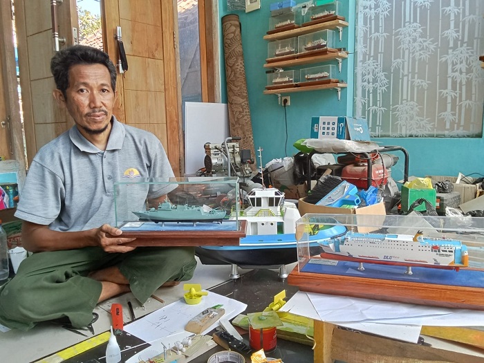 KREATIF: Mohammad Rosul merangkai miniatur kapal di rumah Abdul Halim di Kampung Dumarah, Desa Banyuajuh, Kecamatan Kamal, Bangkalan, Rabu (29/5). (AHZAMZAM ERENDY/JPRM)