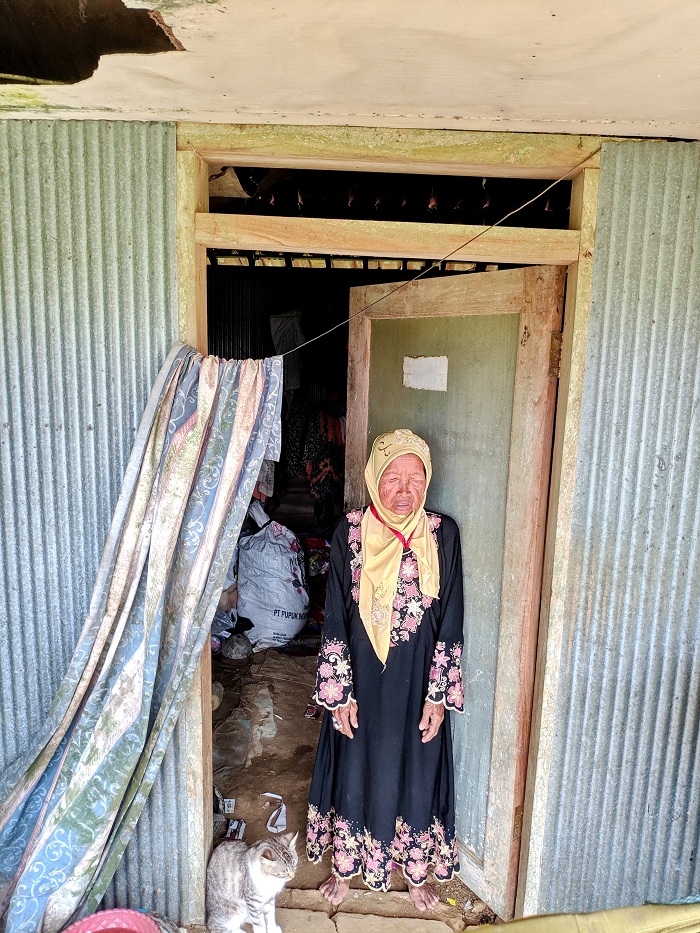 SENDIRI: Hotijah berdiri di pintu rumah di Desa Lergunong, Kecamatan Klampis, Bangkalan, Minggu (2/6). (ACHMAD ANDRIAN FEBRIYANTO/JPRM)