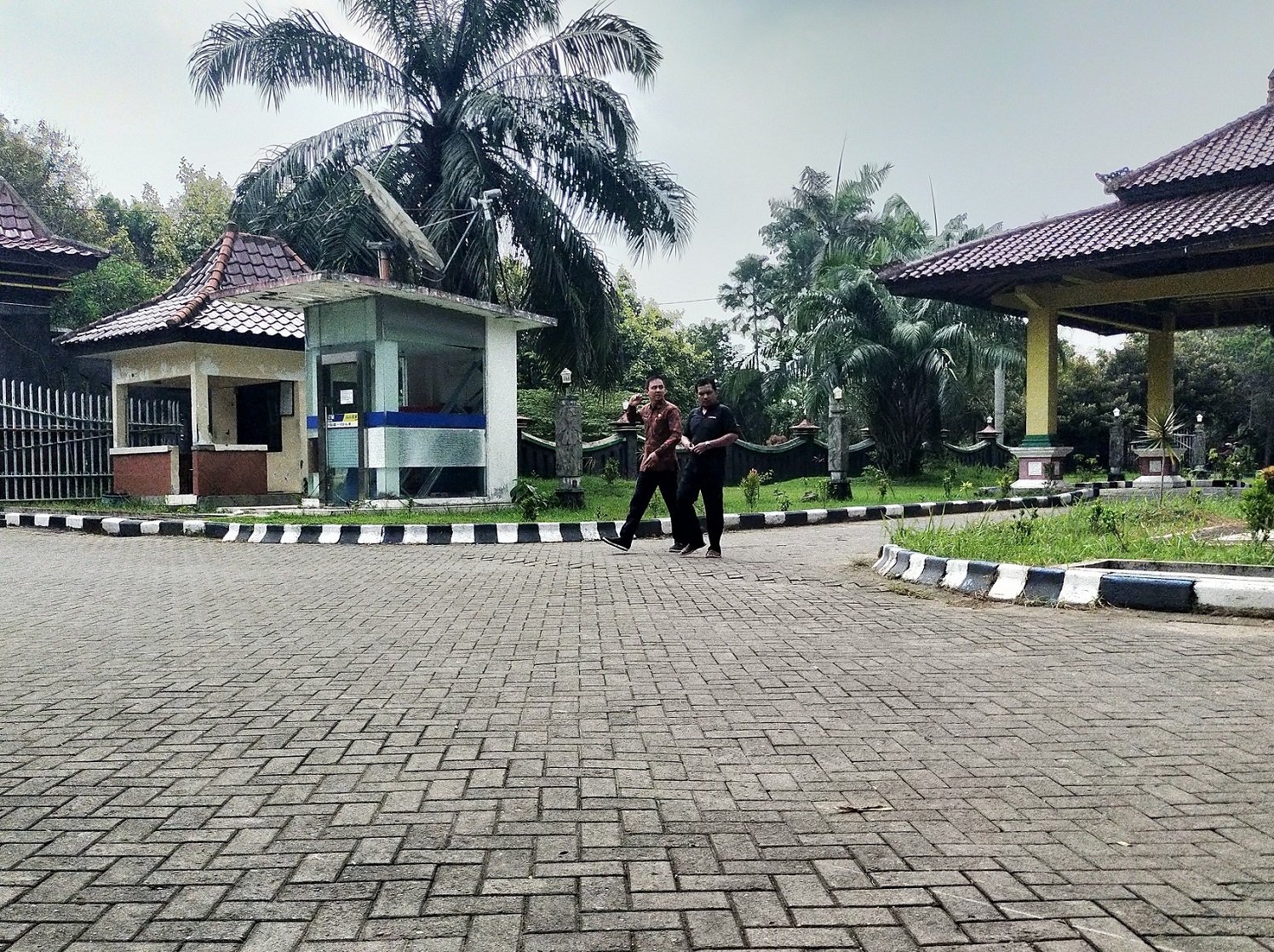 TAPERA: Dua pegawai ASN melintas di halaman Pemkab Bangkalan Jumat (7/6).