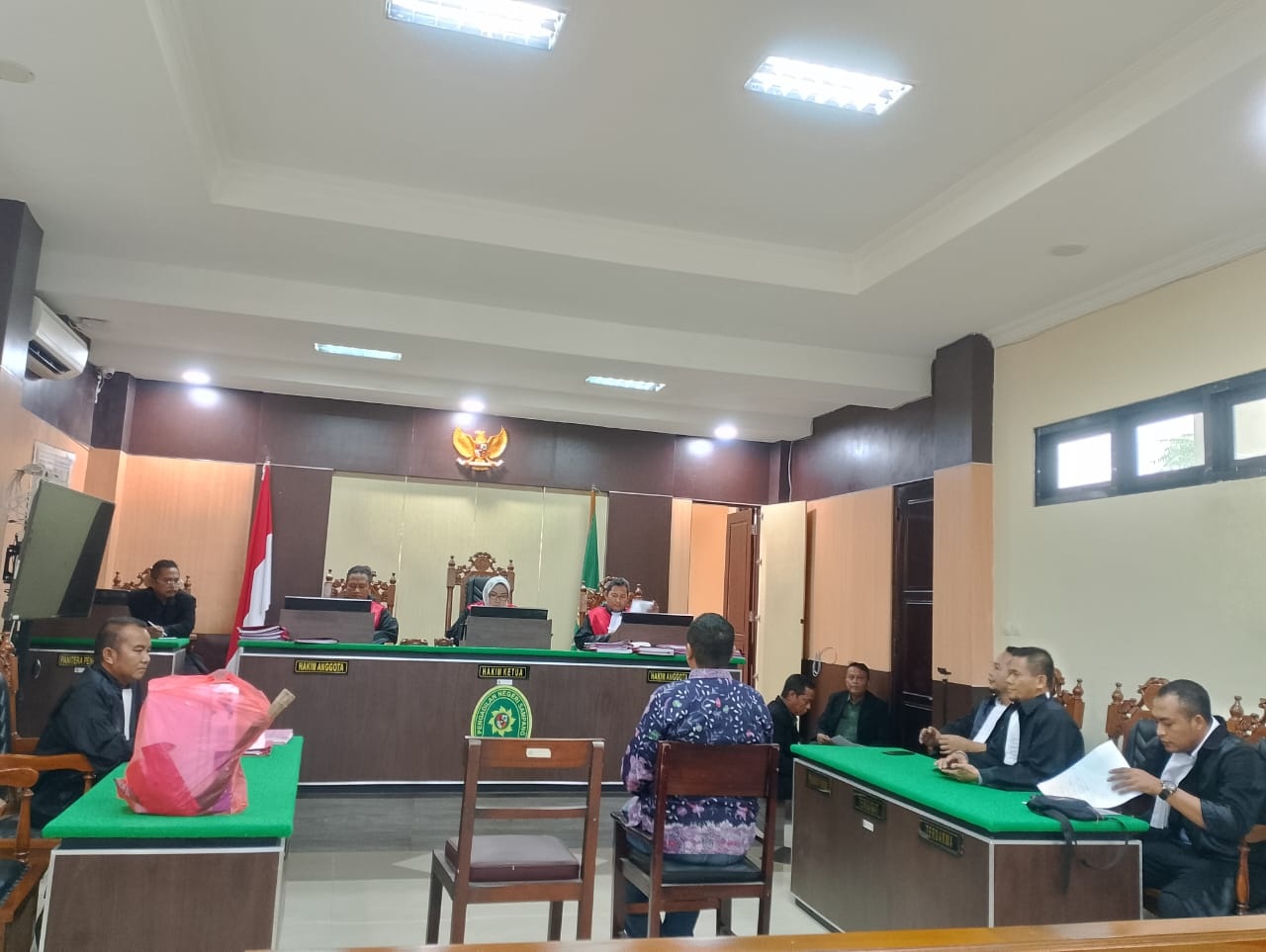 DISIDANG: Pj Kades Ragung Irham Nurdayanto mengikuti sidang pembacaan dakwaan di PN Sampang, Selasa (21/5). (UBAIDILLAHIR RA&rsquo;IE/JPRM)