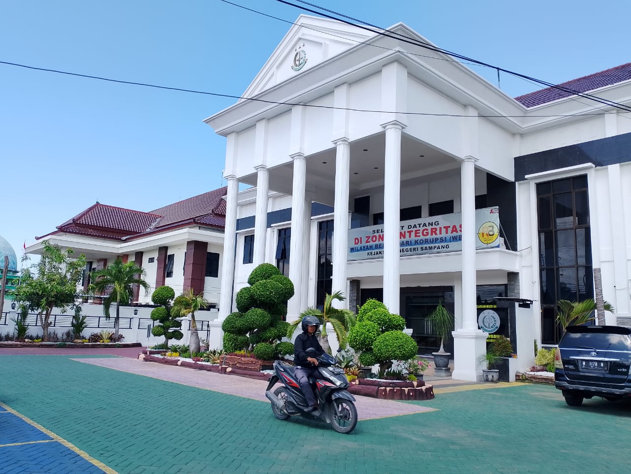CERAH: Warga mengendarai motor di halaman gedung Kejari Sampang kemarin. (UBAIDILLAHIR RA&rsquo;IE/JPRM)