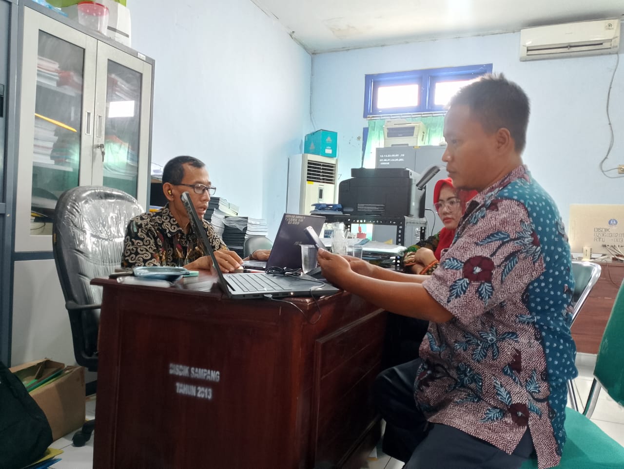 BERTUGAS: Pegawai sedang bertugas di ruang GTK Dispendik Sampang, Jumat (14/6). (UBAIDILLAHIR RA&rsquo;IE/JPRM)