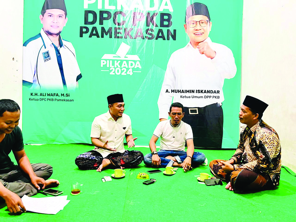 BERSIAP: Ketua Desk Pilkada DPC PKB Pamekasan Khairul Umam (kemeja putih) berdiskusi dengan tim di kantornya. (PKB UNTUK JPRM)