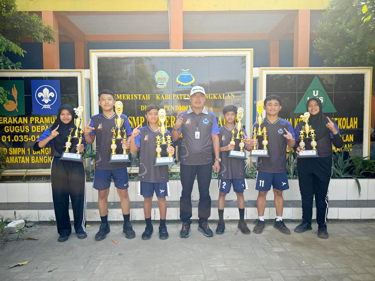 BERPRESTASI: Kepala UPTD SMPN 1 Bangkalan Hermanto (tengah) berfoto bersama anak didiknya yang menyabet juara di ajang O2SN kabupaten, Kamis (20/6). (UPTD SMPN 1 Bangkalan)