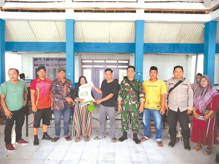 UNTUK WARGA: Pj Kades Karang Penang Onjur Marsuki (tiga dari kiri) bersama perangkat dan aparat menyalurkan bantuan kepada satu penerima sebagai perwakilan Sabtu (22/6).