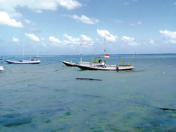 GIGIH: Seorang nelayan turun dari perahu setelah melaut di Desa Masalima, Kecamatan Masalembu, Sumenep. (LINA ALIFIYA ROBBY UNTUK JPRM)