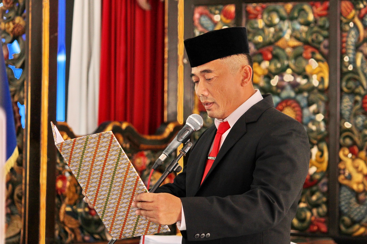 VISIONER: Plt Kepala DPMD Bangkalan Rudiyanto membacakan keputusan bupati tentang perpanjangan masa jabatan Kades di Pendopo Agung Senin (24/6).