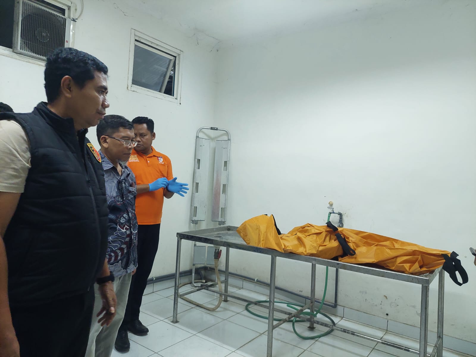 IDENTIFIKASI: Dokter forensik RSUD Syamrabu Bangkalan Edy Suharto saat memeriksa kerangka mayat yang terbakar, Kamis (20/6). (ZEINAL ABIDIN/JPRM)