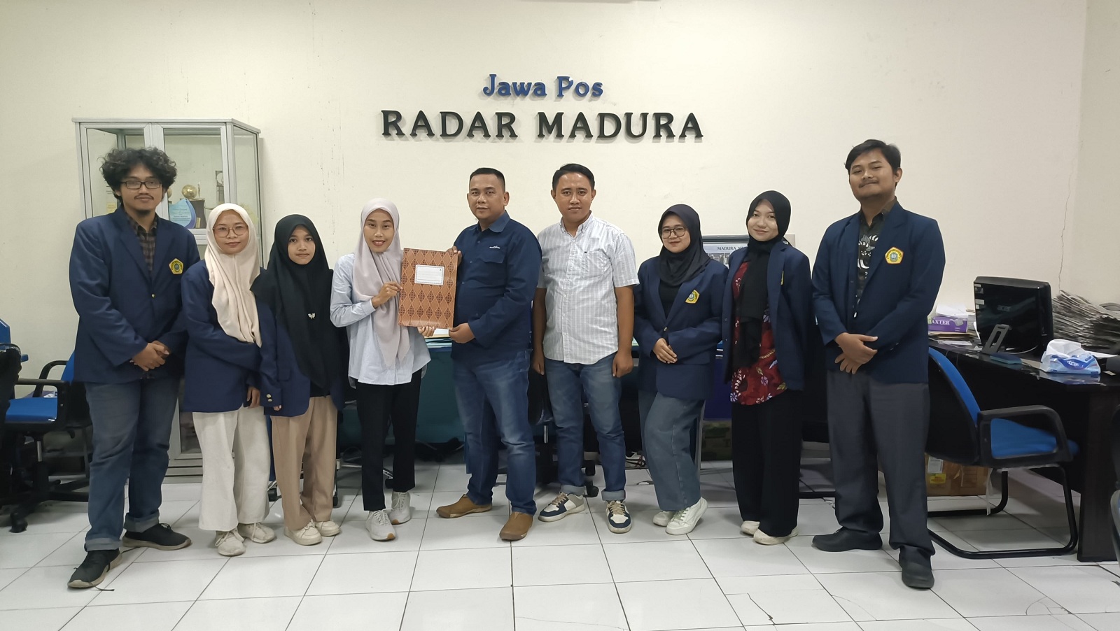 KEMBALI KE KAMPUS: Dosen Sastra Inggris FISIB UTM Evi Pebri Ila Rachma menyerahkan dokumen penjemputan mahasiswa MBKM kepada Pemimpin Redaksi JPRM Luqman Hakim di kantor pusat JPRM, Rabu (26/6).