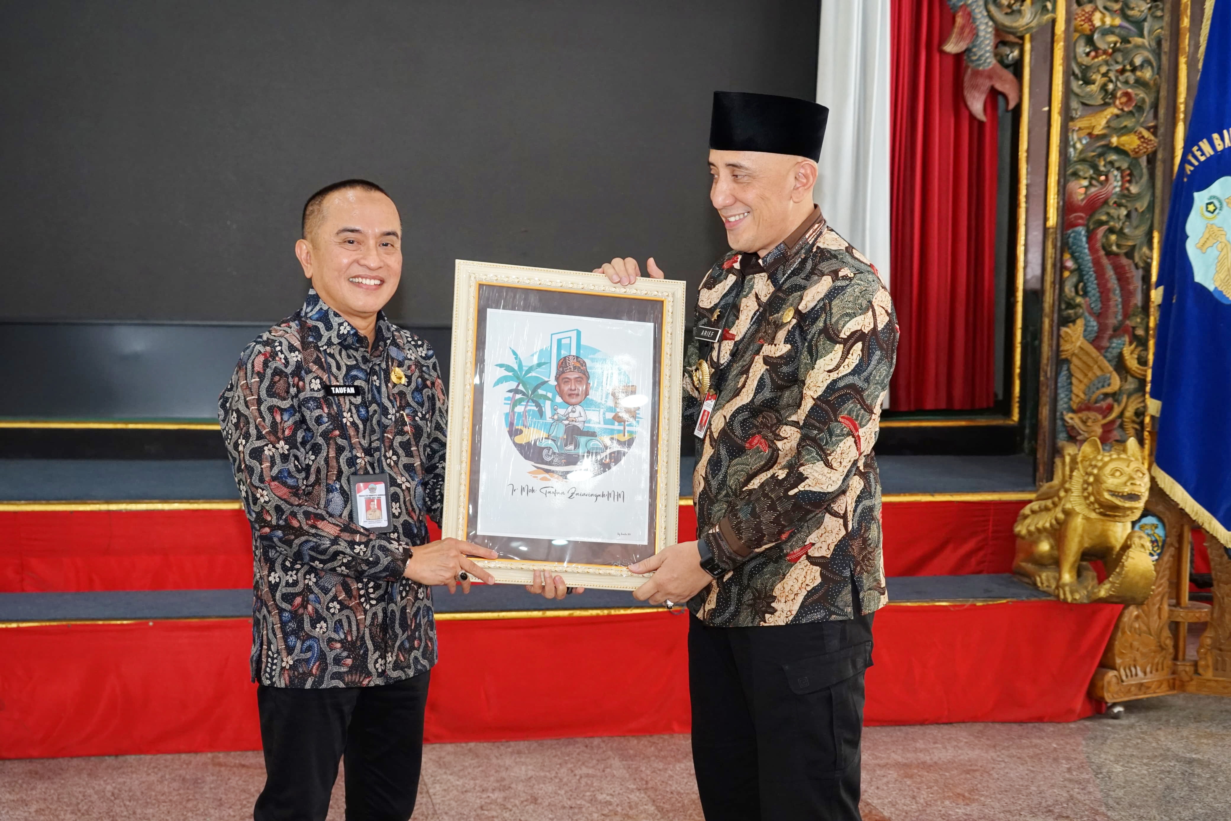 KENANG-KENANGAN: Pj Bupati Bangkalan Arief M. Edie (kanan) memberikan cenderamata kepada Sekkab Bangkalan Moh. Taufan Zairinsjah di Pendopo Agung, Kamis (27/6). (JUPRI/JPRM)