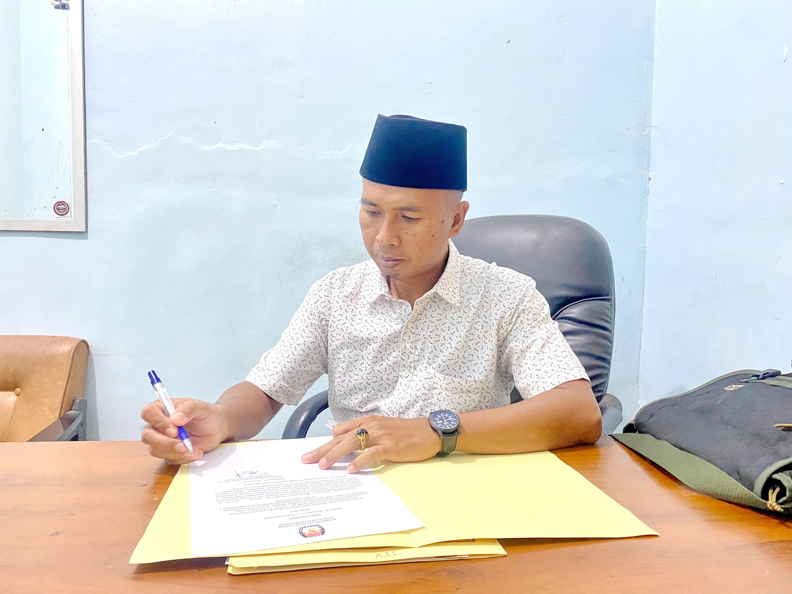 SANTAI: Ketua KPU Pamekasan Mahdi saat ditemui di ruang kerjanya Kamis (27/6).