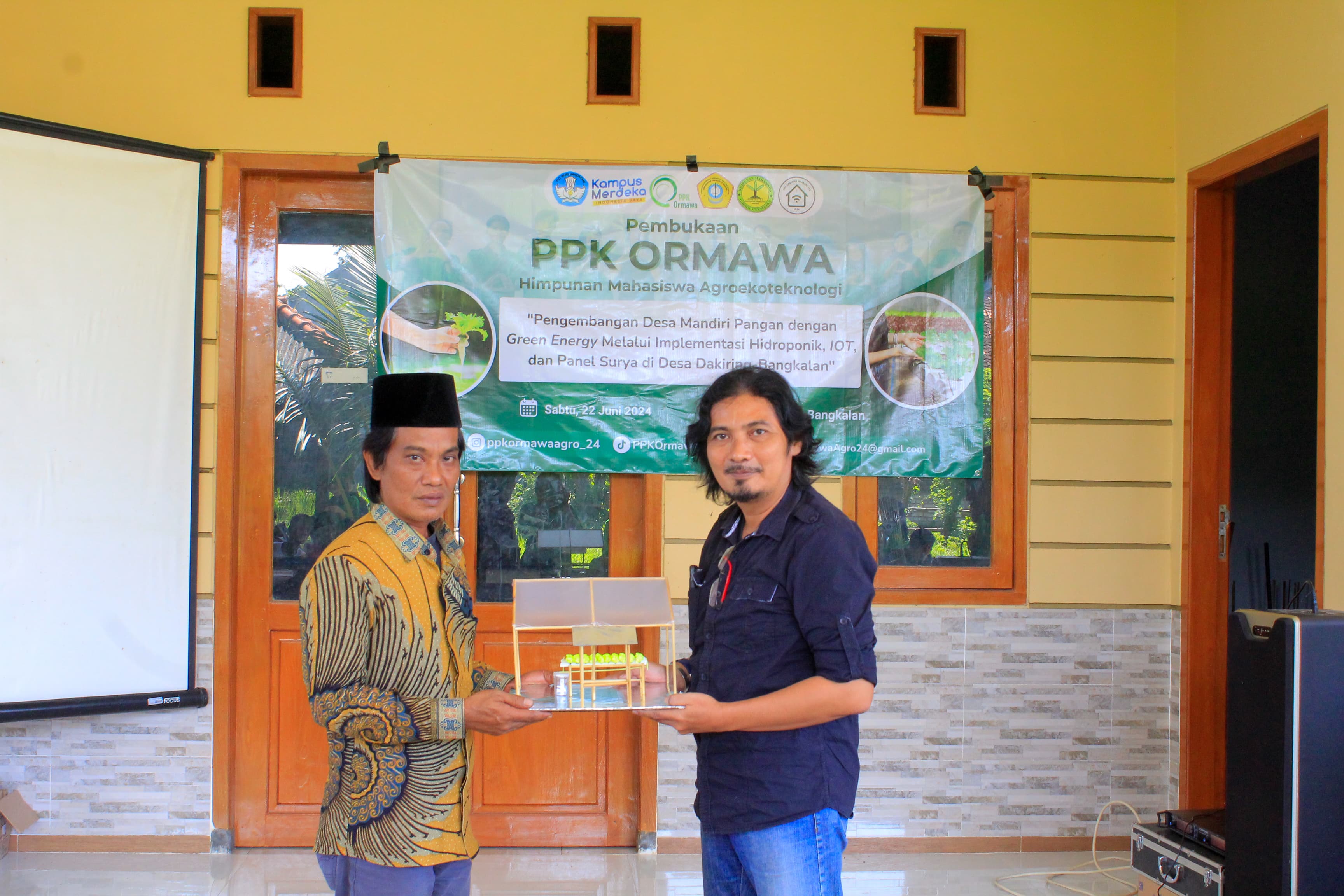 PEMBUKAAN: Wakil Dekan III Bidang Kemahasiswaan Fakultas Pertanian UTM Agus Romadhon menyerahkan secara simbolis mininiatur green house kepada Kepala Desa Dakiring Abd. Rochman, Sabtu (22/6).
