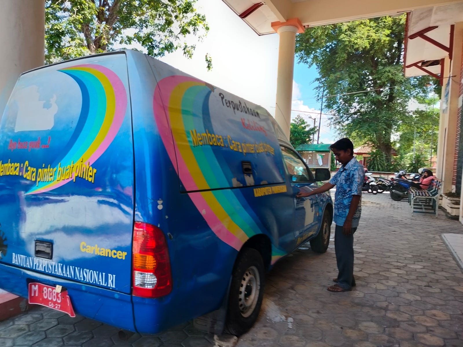 SANTAI: Petugas DPK berada di samping mobil perpusling, Kamis (27/6). (LAILIYATUN NURIYAH/JPRM)