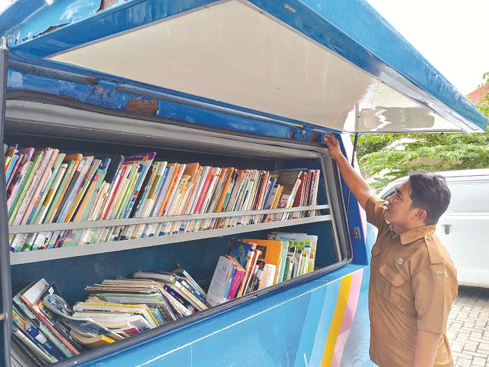 BUTUH PEMELIHARAAN: Petugas perpusling mengecek buku di armada untuk melayani masyarakat Minggu (30/6). (UBAIDILLAHIR RAIE/JPRM)