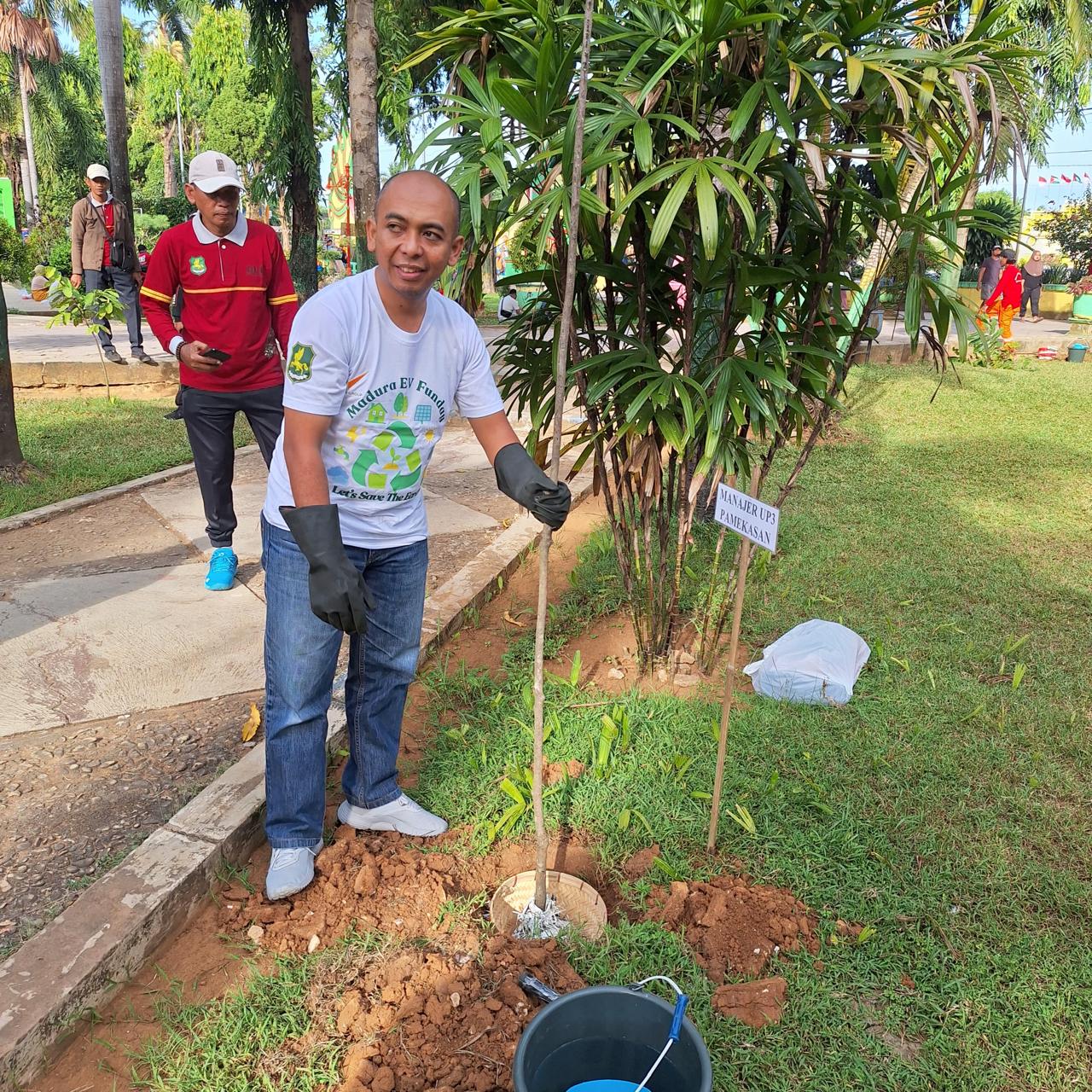 PEDULI LINGKUNGAN: Manager PLN UP3 Pamekasan Fahmi Fahresi menanam pohon secara simbolis di taman Adipura Sumenep, Minggu (30/6).