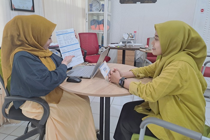 RAMAH: Pegawai Bank Sampang sedang melayani nasabah di kantornya Selasa (2/7). (BANK SAMPANG UNTUK JPRM)