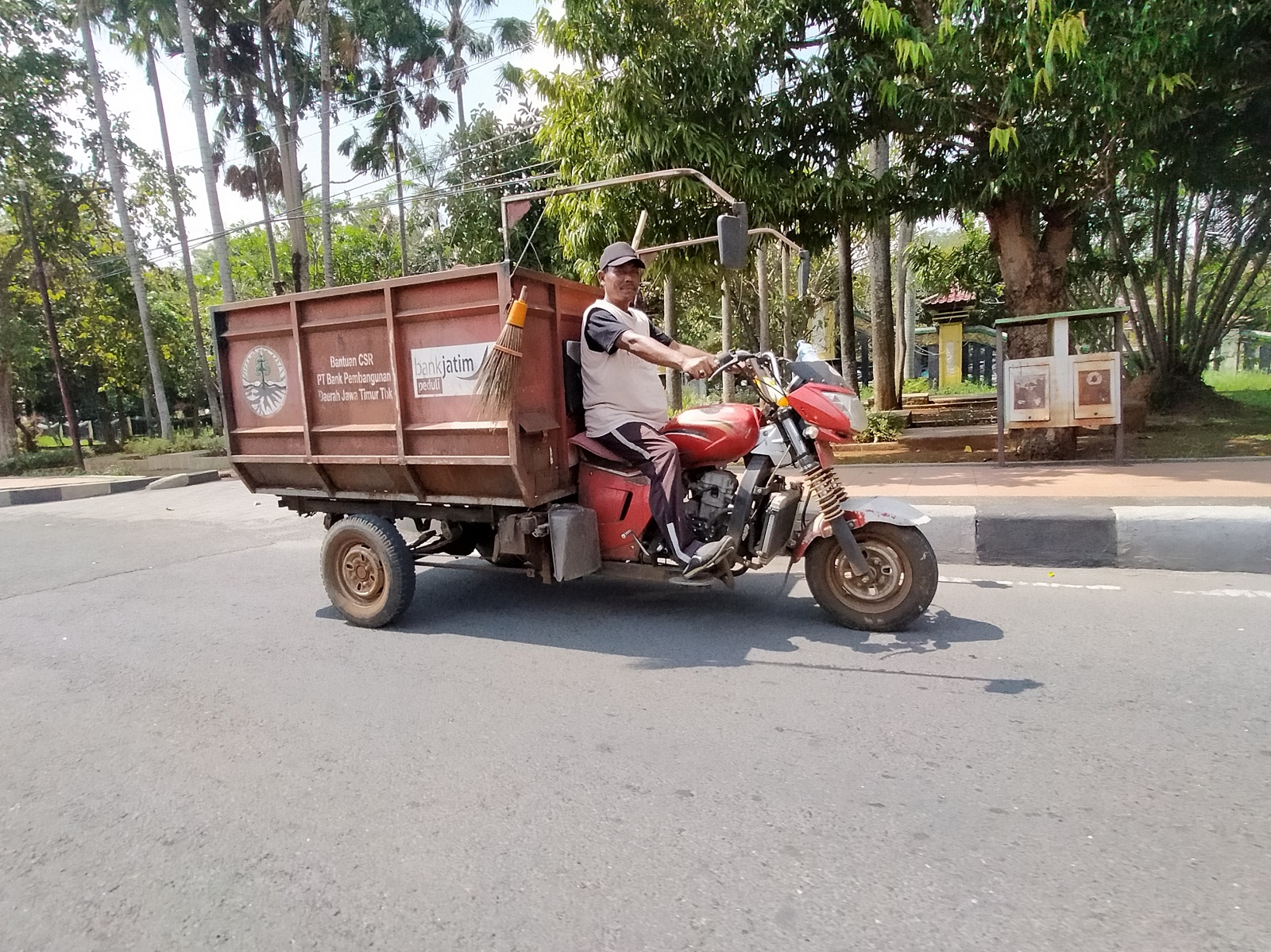 BERTUGAS: Petugas kebersihan melintas di Jalan Soekarno-Hatta, Bangkalan, Kamis (4/7). (VIVIN AGUSTIN HARTONO/JPRM)