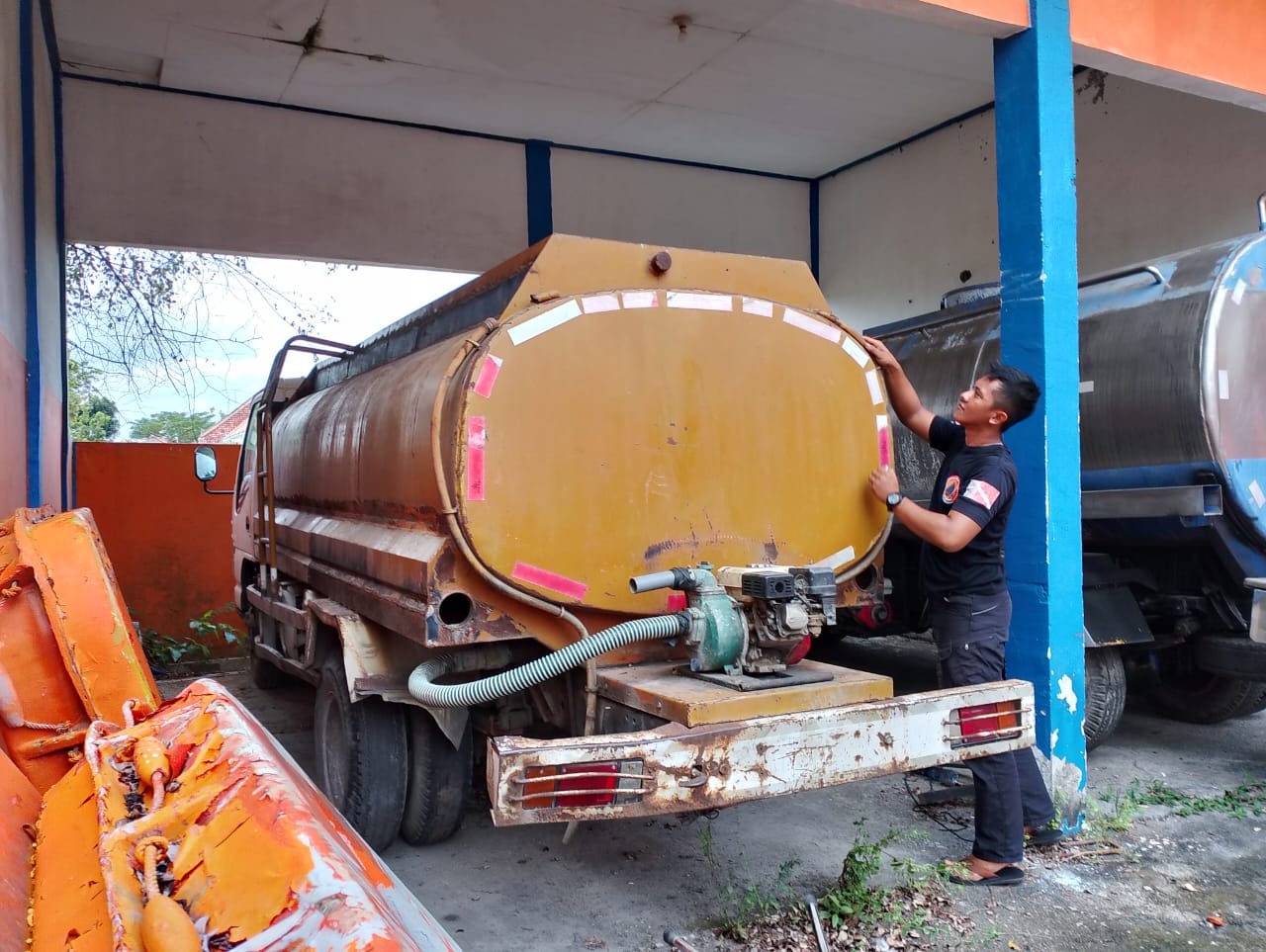 KAWASAN KEKERINGAN BERTAMBAH: Karyawan BPBD Sampang sedang mengecek armada yang terparkir di kantornya Kamis (4/7).