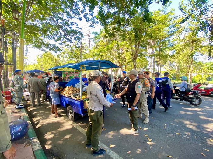BERSITEGANG: Satpol PP dan Damkar Pamekasan menertibkan pedagang di sekitar Monumen Arek Lancor Pamekasan, Jumat (5/7). (MOH. IQBAL AFGANI/JPRM)