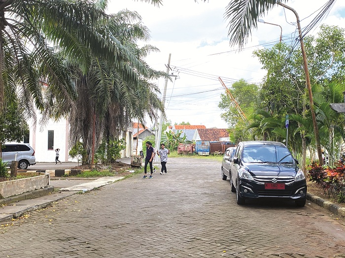 PARKIR: Warga sedang berjalan di sekitar kendaraan dinas kantor Pemkab Bangkalan, Jumat (5/7). (AYU LATIFAH/JPRM)