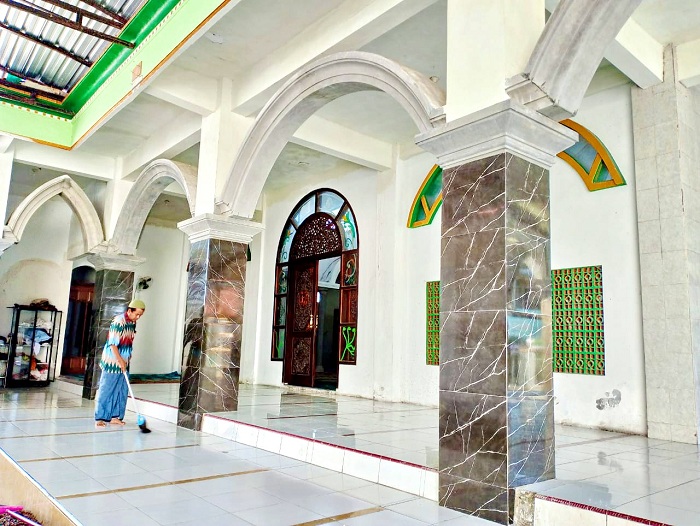 RAJIN: Marbot Masjid Al-Furqon, Kelurahan Karang Dalem, Sampang, Fathor Rahman sedang menyapu teras masjid, Jumat (5/7). (UBAIDILLAHIR RA&rsquo;IE/JPRM)