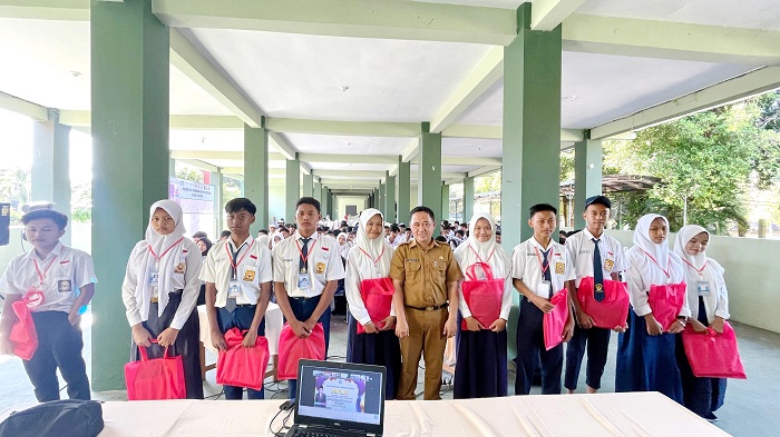 PEDULI: Kepala SMA Negeri 1 Ketapang Sulaiman (baju cokelat) usai memberikan bantuan seragam kepada siswa baru di sekolahnya Senin (15/7). (SMAN 1 KETAPANG UNTUK JPRM)