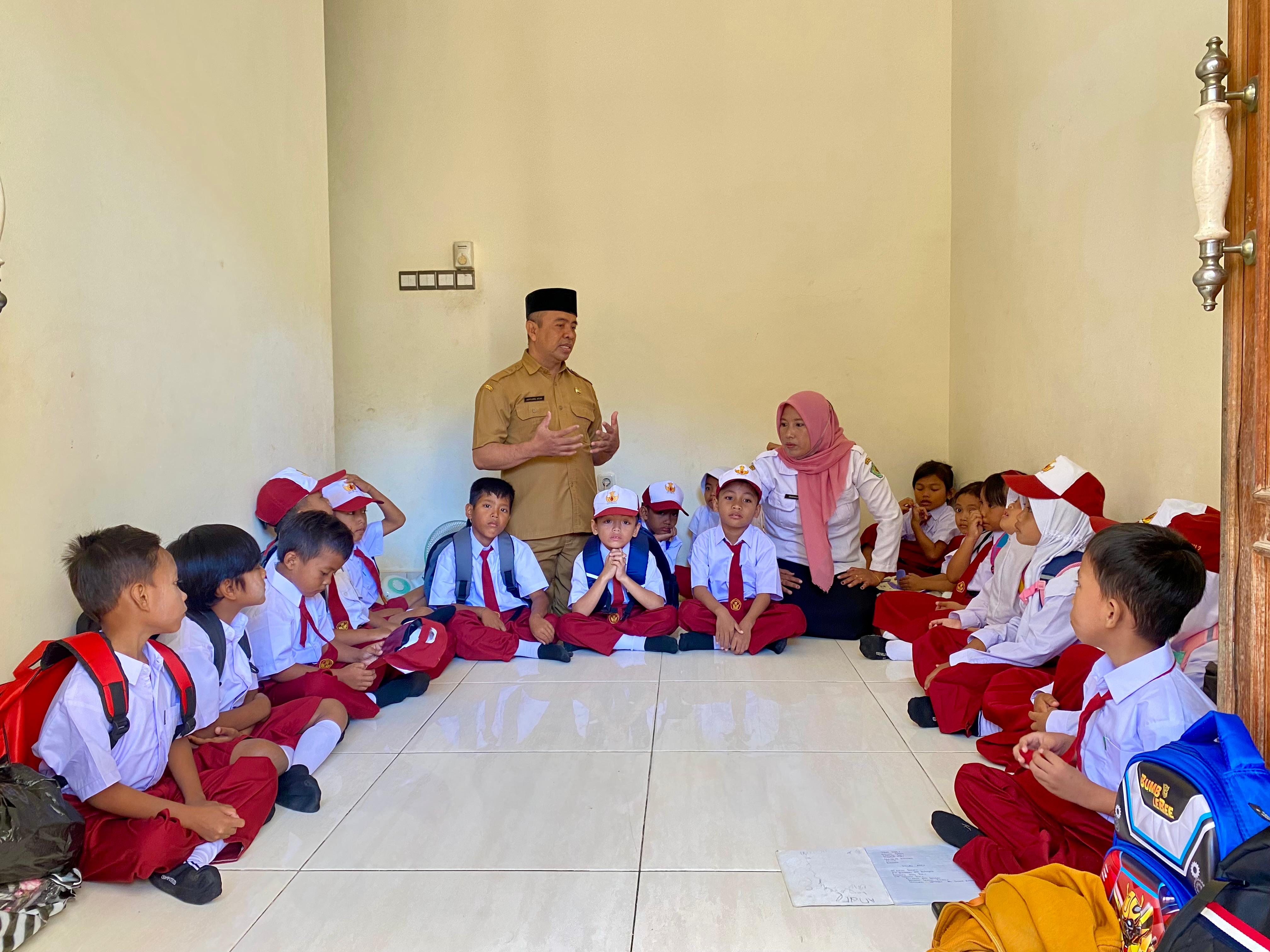 MENUMPANG: Siswa SDN Tamberu 2 belajar di rumah warga karena sekolah mereka masih disegel, Senin (15/7). (MOH. IQBAL AFGANI/JPRM)