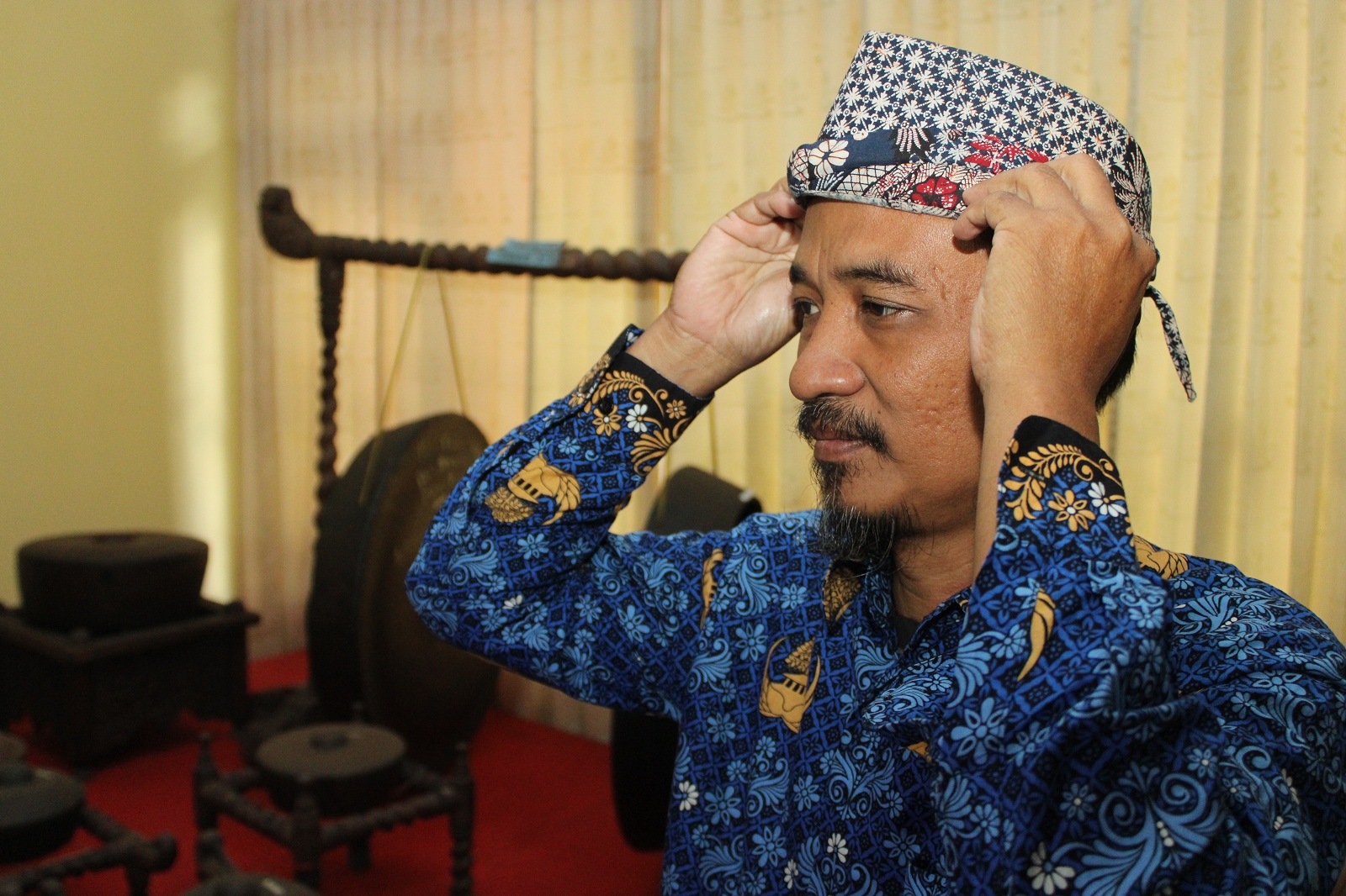 WARISAN LELUHUR: Pegawai Dinas Kebudayaan dan Pariwisata (Disbudpar) Bangkalan mengenakan tongkos, Rabu (17/7). (VIVIN AGUSTIN HARTONO/JPRM)