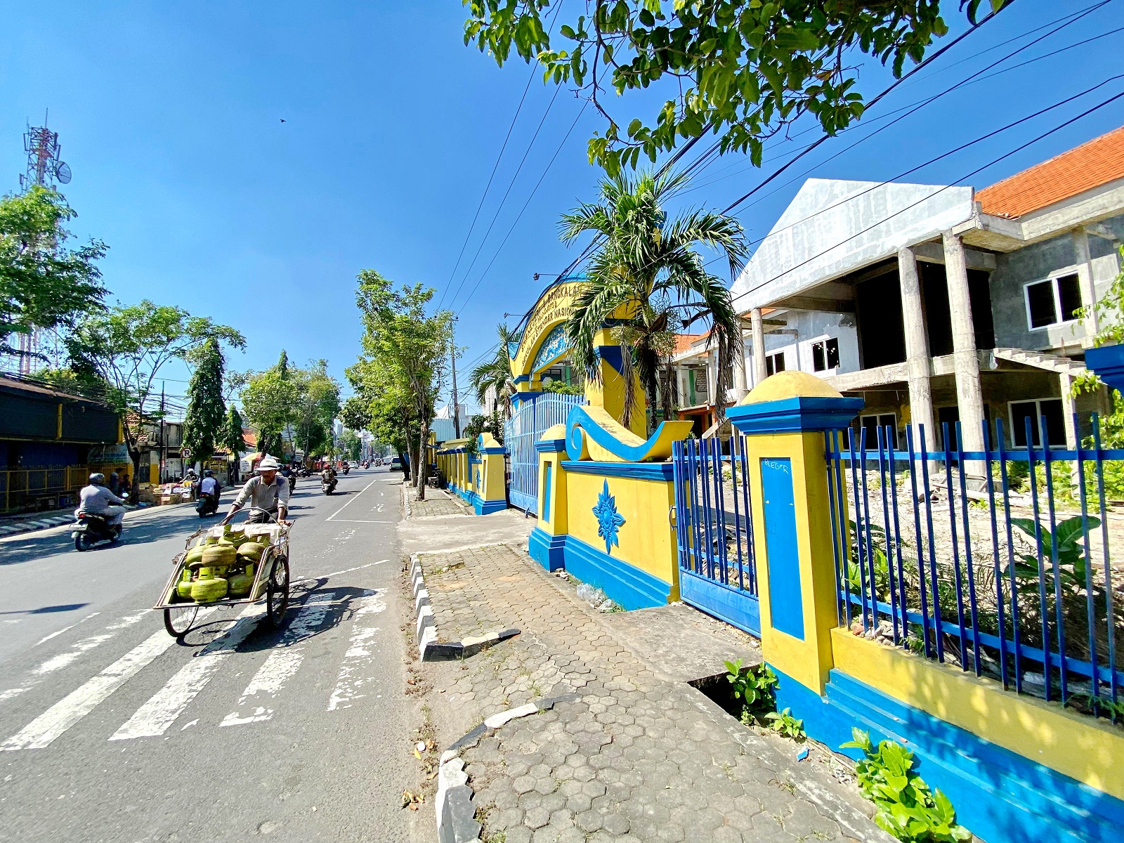 TERBENGKALAI: Pengendara motor melintas di depan boarding school UPTD SMPN 1 Bangkalan Selasa (16/7).