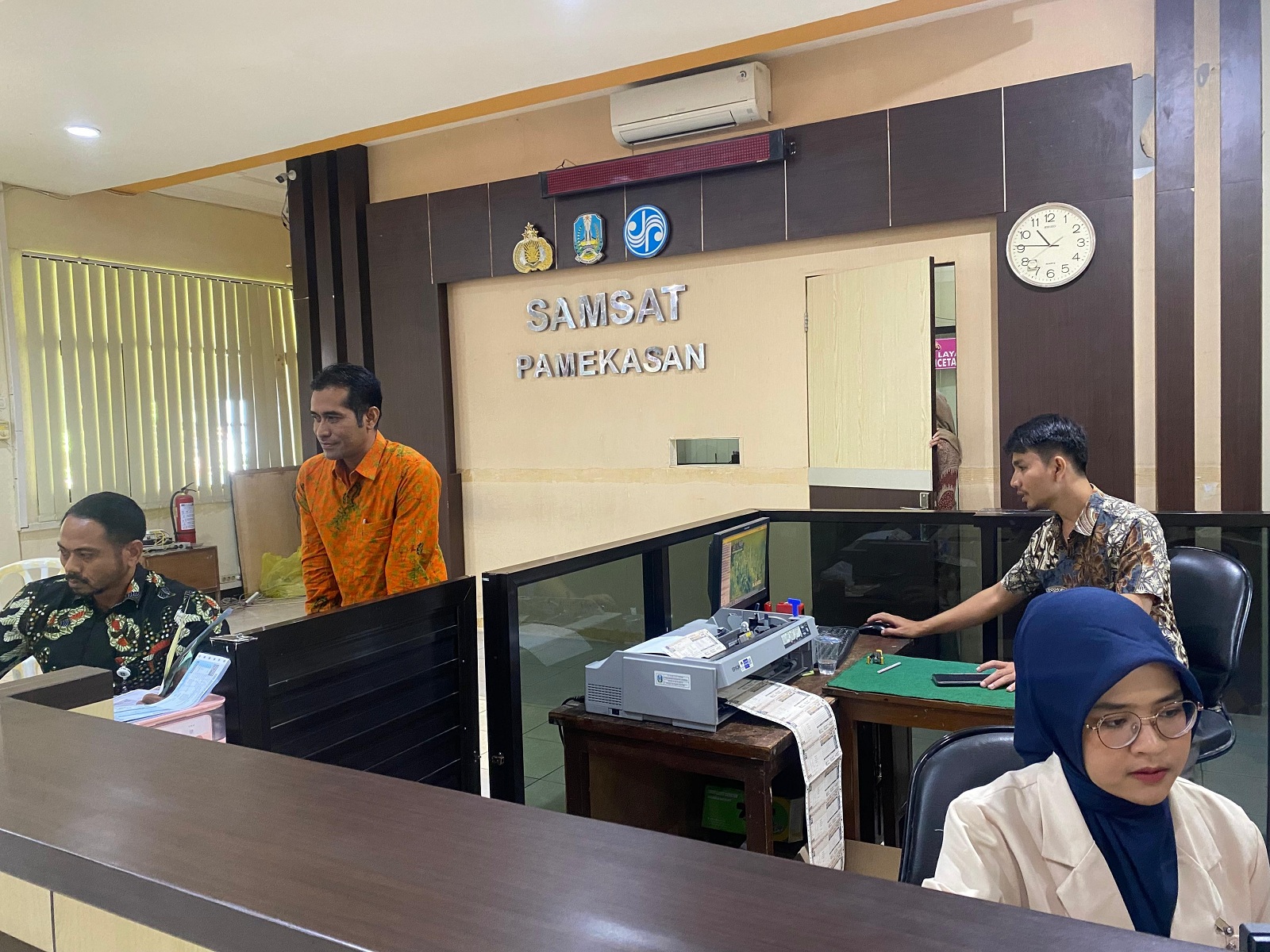 LAYANAN NORMAL: Petugas melayani masyarakat di KB Samsat Pamekasan, Jumat (19/7). (MOH. IQBAL AFGANI/JPRM)