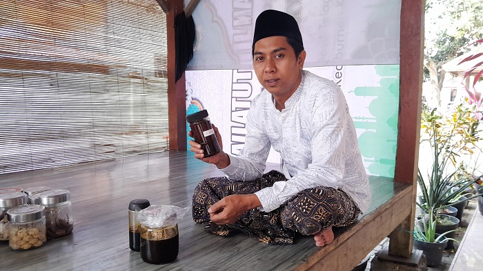 JAMU TRADISIONAL: Mansour Achmad menunjukkan produk madu olor yang sudah siap dipasarkan, Minggu (21/7). (M. KHOLIL RAMLI/JPRM)