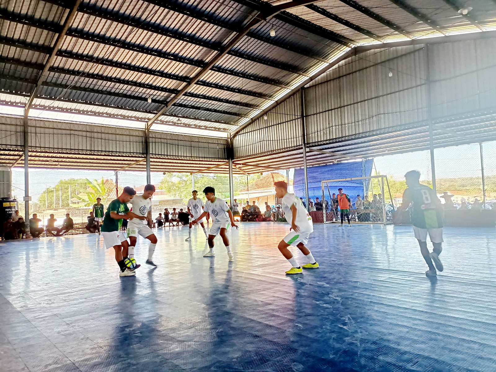 ADU KEMAMPUAN: Pemain futsal berebut bola dalam kompetisi futsal di GOR Desa Rombuh, Kecamatan Palengaan, Pamekasan, Jumat (26/7).