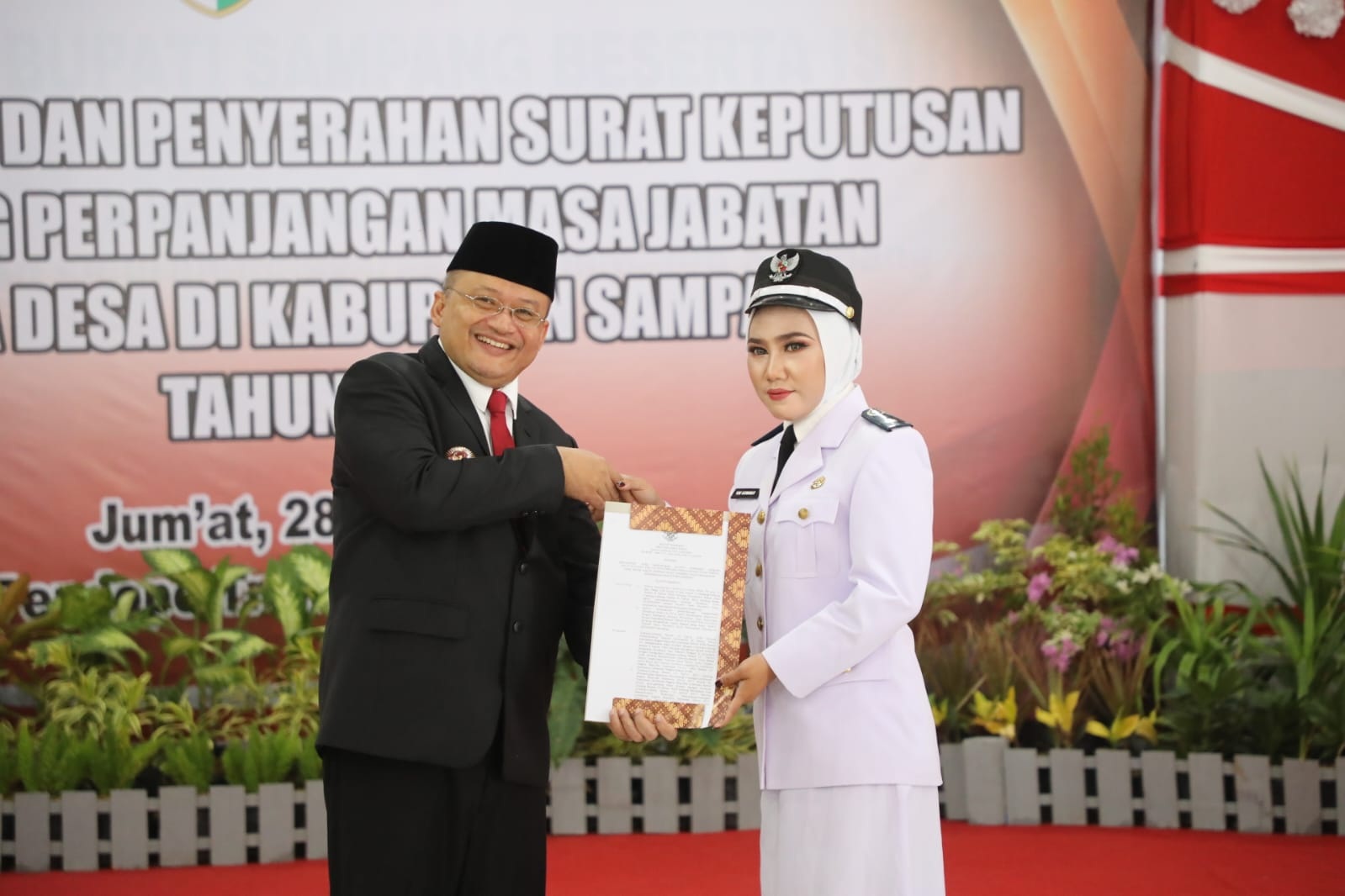 PENGABDIAN: Kades Tamberu Daya Yuni Kusmawati (kanan) menerima SK perpanjangan masa jabatan Kades di Pendopo Bupati Sampang, Jumat (28/6). (PEMDES TAMBERU DAYA UNTUK JPRM)