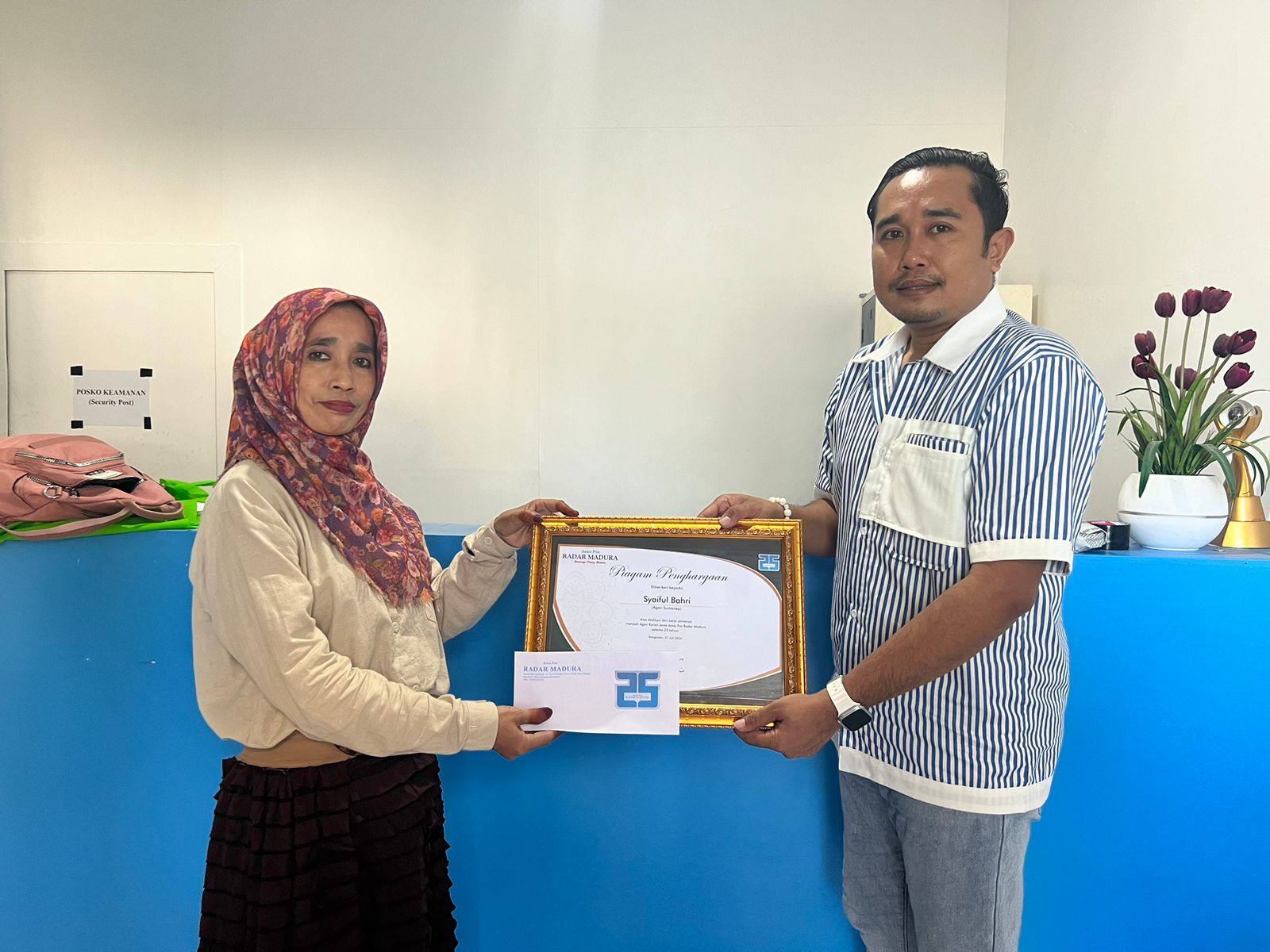 BANGGA: Wakabiro JPRM Sumenep Hendra Purwadi memberikan penghargaan kepada H. Susmiyati istri Alm. H. Mujiburrahman pemilik Agen Syaiful Bahri, Senin (29/7).