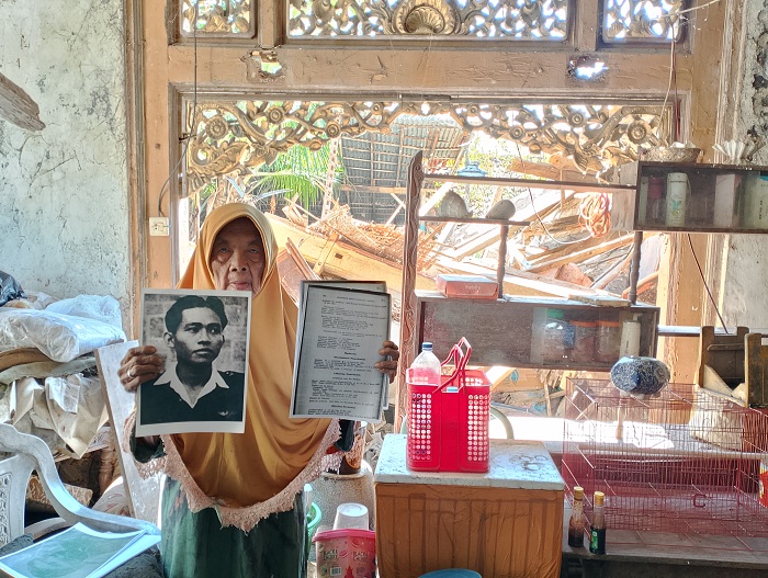BERSEJARAH: Supradani menunjukkan buku silsilah dan foto pahlawan nasional Halim Perdanakusuma yang disimpan di rumahnya, Minggu (4/8). (UBAIDILLAHIR RAIE/JPRM)