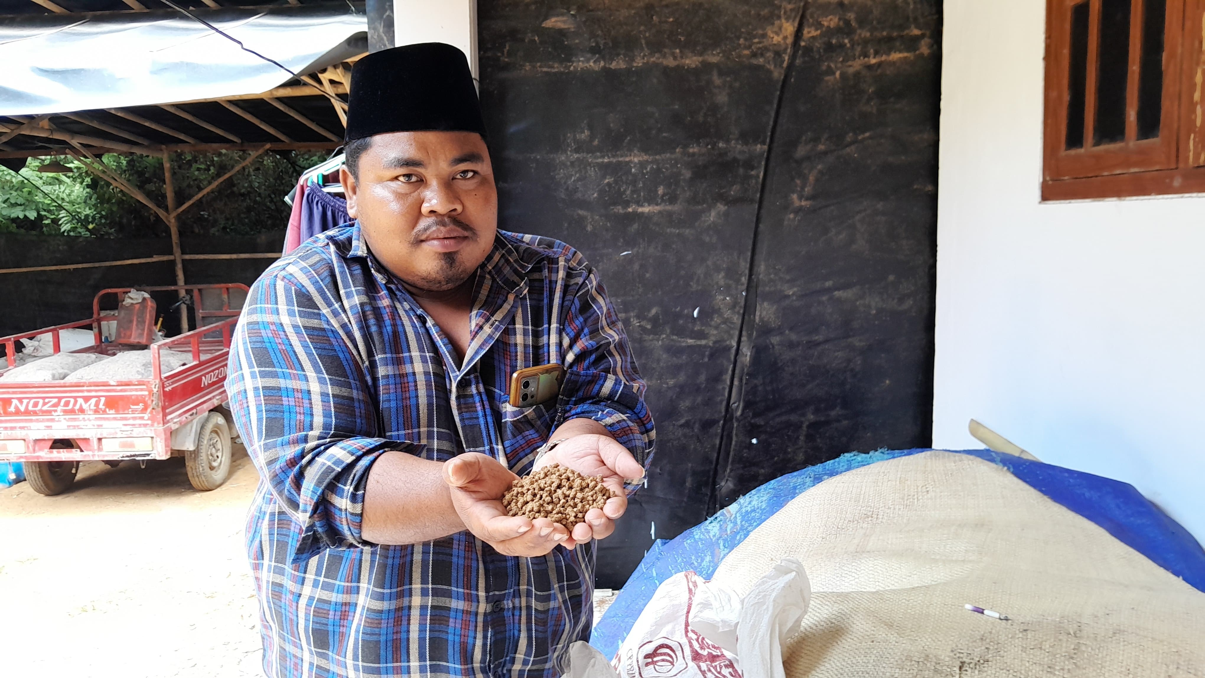 PRODUKSI SENDIRI: Abu Yasid menunjukkan produksi pelet lelenya Kamis (1/8). (M. KHOLIL RAMLI/JPRM)