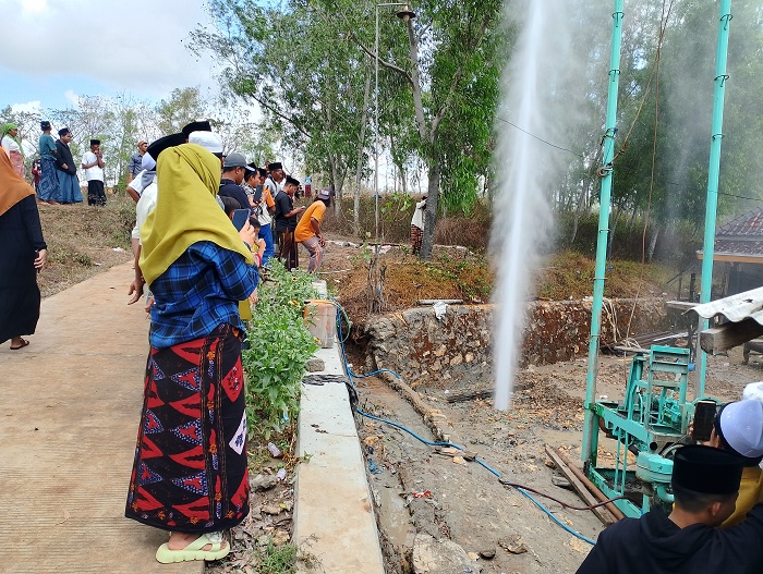 SUDAH SURUT: Warga berada di sekitar semburan air sumur bor di Desa Pandan, Kecamatan Omben, Sampang, Jumat (2/8). (UBAIDILLAHIR RAIE/JPRM)