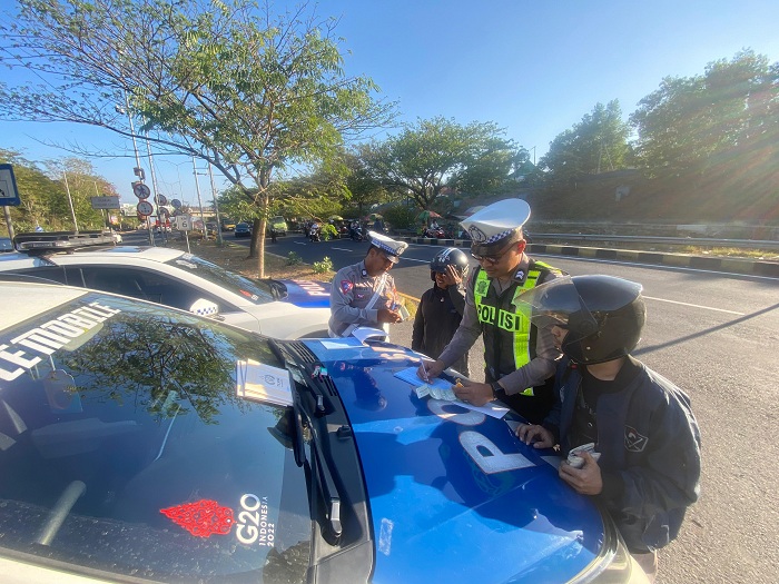 TEGAS: Anggota Satlantas Polres Bangkalan menilang pengendara sepeda motor masuk jalur mobil di Jembatan Suramadu, Jumat (2/8). (SATLANTAS POLRES BANGKALAN UNTUK JPRM)