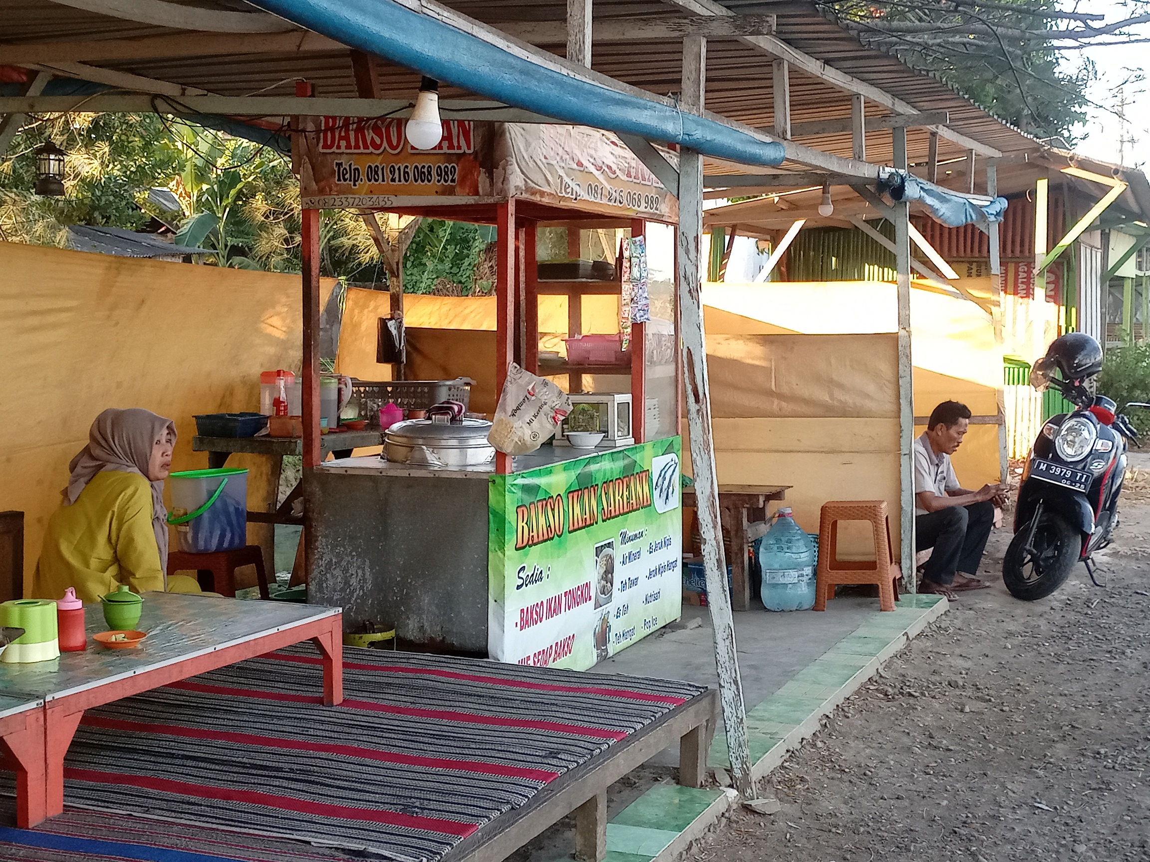 BERNIAGA: Seorang penjual olahan bakso ikan di kawasan ikan bakar talangan, Desa Pabian, Kecamatan Kota Sumenep, menunggu pembeli, Sabtu (20/7). (MOH. LATIF/JPRM)