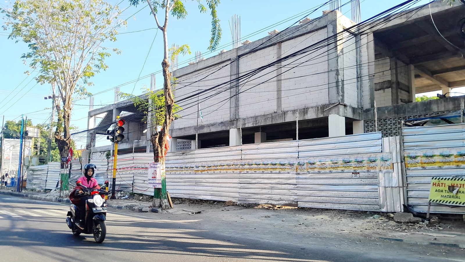 PROYEK MILIARAN: Warga sedang beraktivitas di sekitar bangunan perpustakaan dan kearsipan Pamekasan Minggu (4/8).
