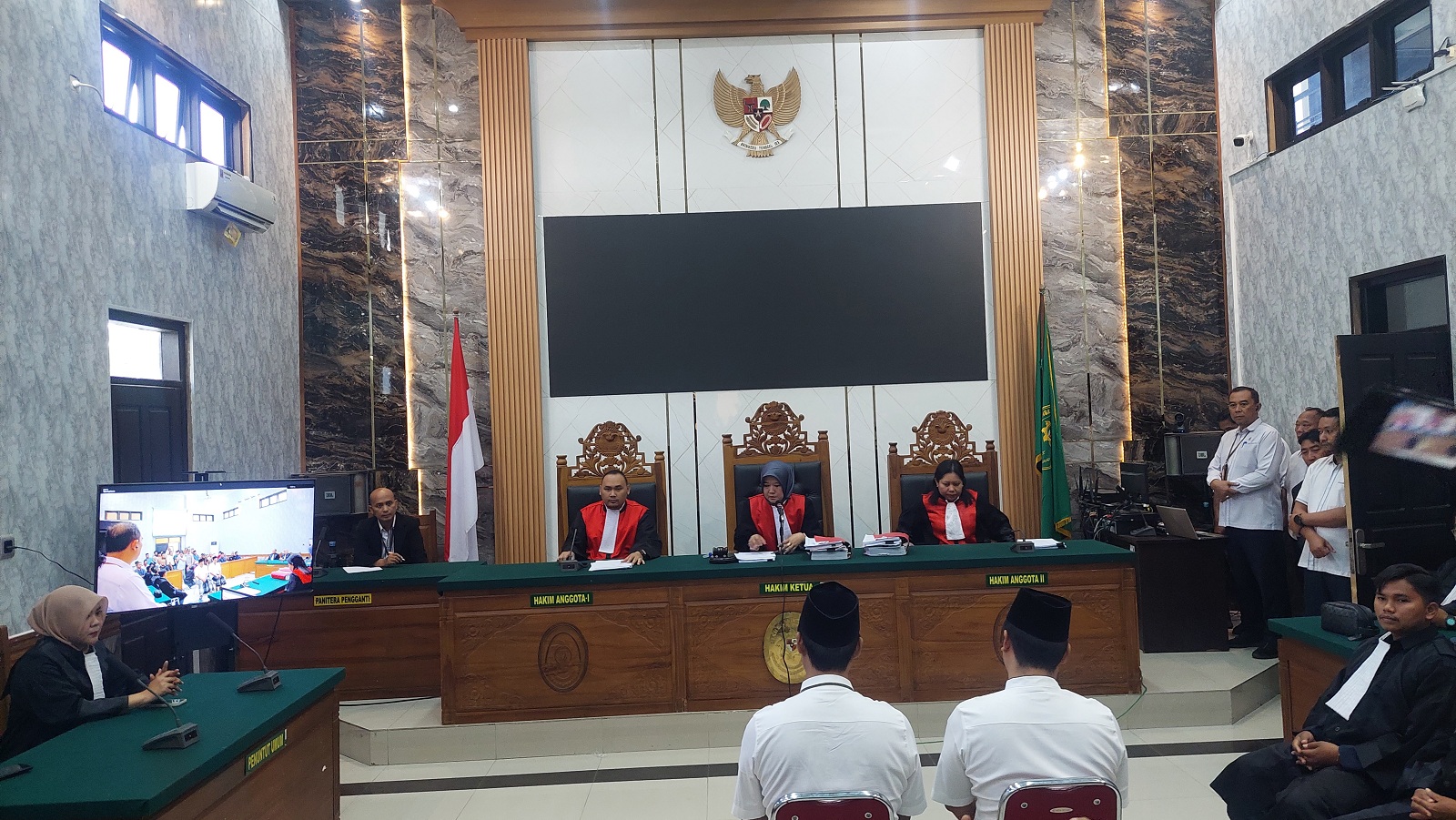 KAKAK BERADIK: Hasan Basri dan Mohammad Wardi menjalani sidang pembunuhan di Pengadilan Negeri Bangkalan, Senin (5/8). (ZEINAL ABIDIN/JPRM)