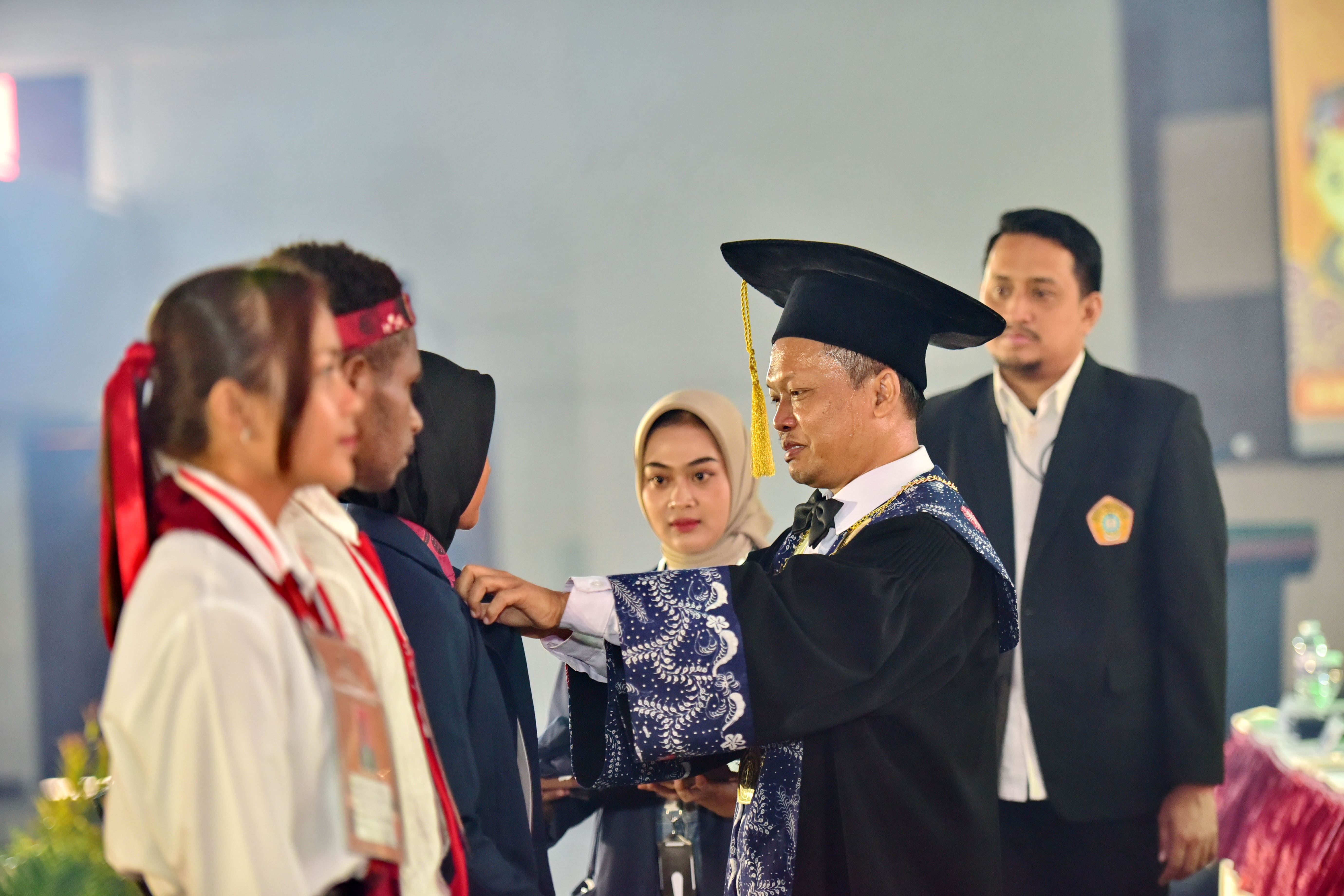 UTM UNTUK JPRMPEMBUKAAN: Rektor UTM Safi memakaikan almamater kepada mahasiswa baru, Senin (5/8). (UTM UNTUK JPRM)