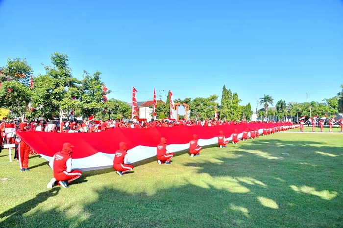 KOMPAK: Pembentangan bendera Merah Putih sepanjang 79 meter di halaman Pemkab Sumenep pada Senin (5/8). (PROKOPIM SUMENEP UNTUK JPRM)